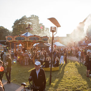 Ulkotapahtuma. Karuselli, auringonlasku, savua.