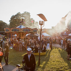 Ulkotapahtuma. Karuselli, auringonlasku, savua.