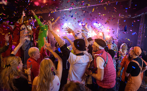 Ihmiset juhlimassa konfettisateessa