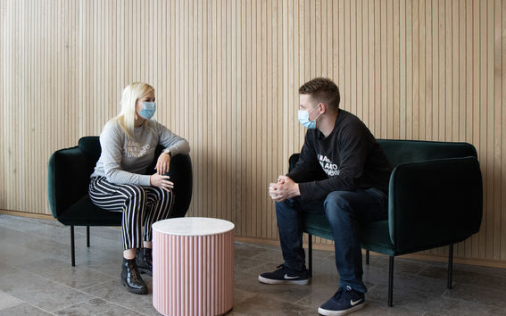 Kaksi opiskelijaa istuu kasvomaskit naamallaan pöydän ääressä