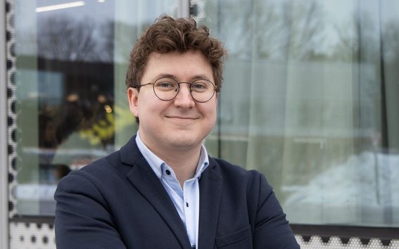 Hallituksen jäsen seisoo tyytyväisen näköisenä.