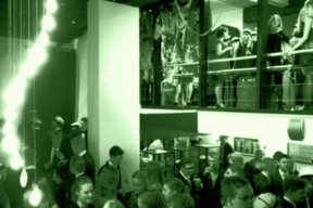 Vihreäksi sävytetty kuva, jossa näkyy paljon ihmisiä museolla.