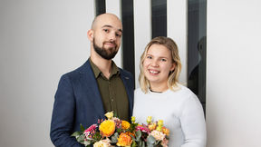 Sakari ja Tilda hymyilevät ja pitävät kädessään kukkakimppuja