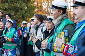 Opiskelijat kuuntelevat puhetta hymyillen, käsissä kuohuviinilasit