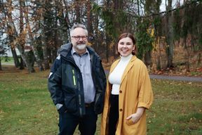 Simo ja Sonja seisovat ulkona, hymyilevät