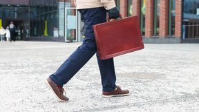 Mies kävelee Väreen edessä salkku kädessä, kuvassa vain jalat