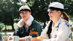 Kaksi opiskelijaa istuu terassilla kahvikupit kädessä