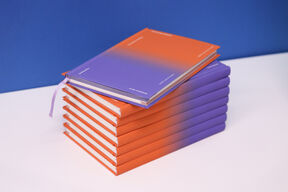 Kuvassa pinottuna kahdeksan edellisen suunnittelijan Design Notebookia