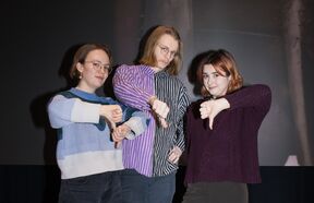 AYY:n hallituksen jäsenet Kerttu, Antti ja Brynna näyttävät alapeukkua