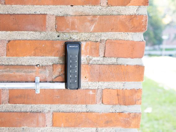 Musta kulkukoodilaite tiiliseinällä