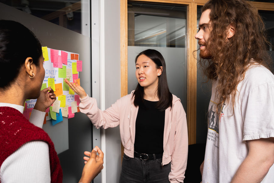 opiskelijoita tutkimassa post-it -lappuja