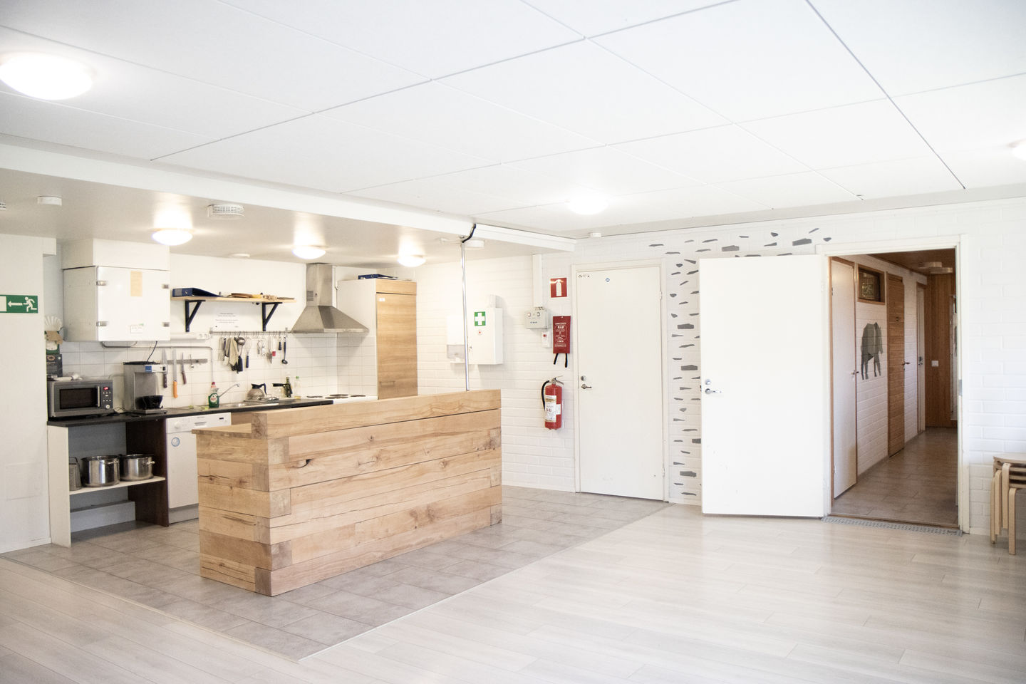 Ossinsaunan keittiö ja avonainen ovi saunatilaan