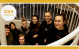 7 young people smiling and standing in the stairway