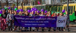Students walking with a banner "The best students life in the world"